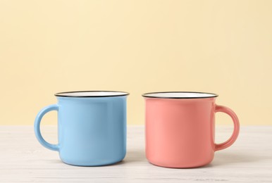 Blue and pink mugs on white wooden table. Gender equality