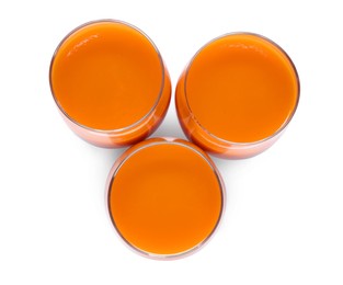 Three glasses of fresh carrot juice on white background, top view