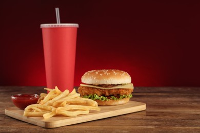 Photo of Delicious fast food menu on wooden table against red background. Space for text