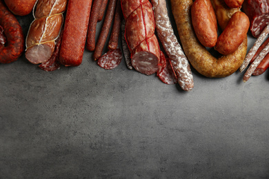 Different types of sausages on grey background, flat lay. Space for text