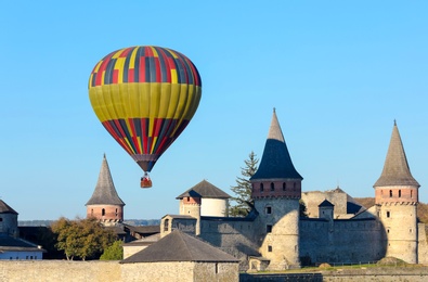 KAMIANETS-PODILSKYI, UKRAINE - OCTOBER 06, 2018: Beautiful view of hot air balloon flying near Kamianets-Podilskyi Castle