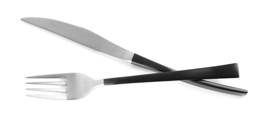 Photo of New fork and knife with black handles on white background, top view