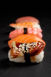 Photo of Delicious nigiri sushi on black table. Traditional Japanese cuisine