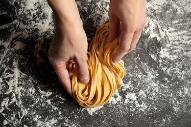 Woman holding pasta at table, top view