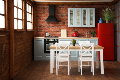 Photo of Stylish kitchen interior with wooden table and chairs