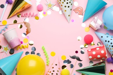 Frame of party hats and other festive items on pink background, flat lay with space for text. Birthday surprise