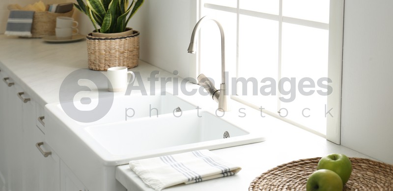 Image of New ceramic sink and modern tap in stylish kitchen interior. Banner design