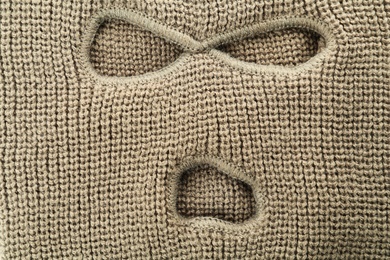 Photo of Beige knitted balaclava as background, closeup view