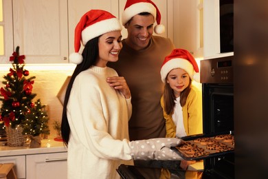 Happy family baking delicious Christmas cookies at home