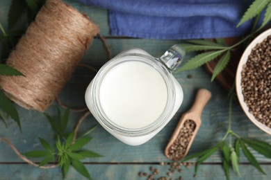 Flat lay composition with fresh hemp milk on light blue wooden table