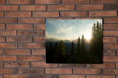 Canvas with printed photo of forest and mountain landscape on brick wall, space for text