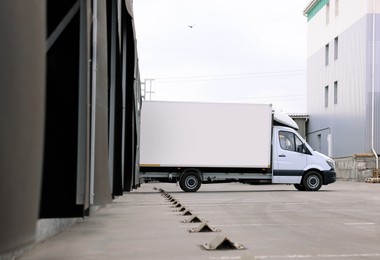 Truck near loading dock of warehouse outdoors. Logistics center
