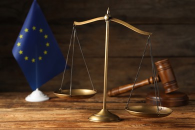 Scales of justice, judge's gavel and European Union flag on wooden table