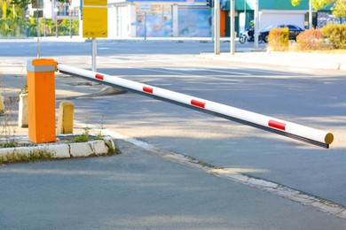 Photo of Closed boom barrier near road on autumn day outdoors