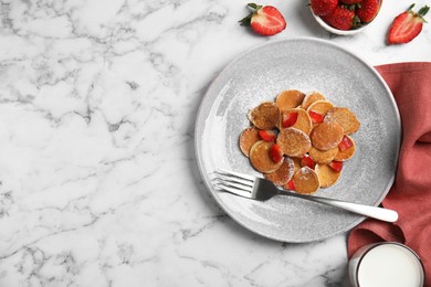 Delicious mini pancakes cereal with strawberries served on white marble table, flat lay. Space for text