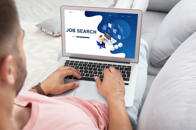 Man searching job with laptop at home, closeup  