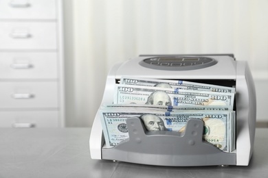 Modern bill counter with money on table indoors