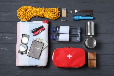 Photo of Disaster supply kit for earthquake on black wooden table, flat lay