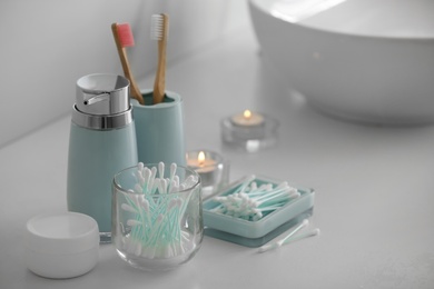 Cotton buds and toiletries on white countertop