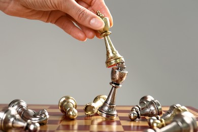 Woman moving chess piece on board, closeup