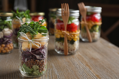 Glass jar with healthy meal on wooden table