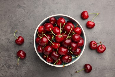 Photo of Bowl with ripe sweet cherries on grey table, flat lay
