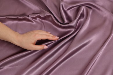 Photo of Woman touching smooth silky fabric, top view