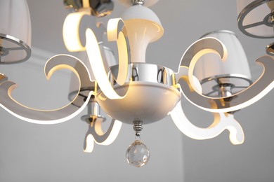 Photo of Stylish chandelier on ceiling in room, closeup