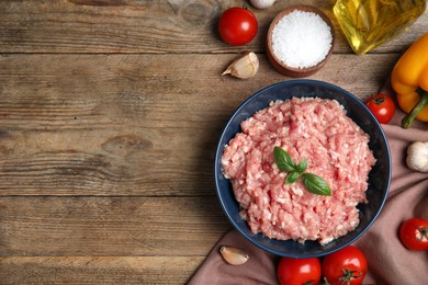 Raw chicken minced meat and ingredients on wooden table, flat lay. Space for text