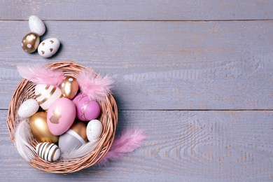 Photo of Flat lay composition with festively decorated Easter eggs on grey wooden background. Space for text