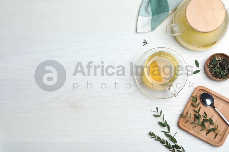 Aromatic eucalyptus tea on white wooden table, flat lay. Space for text