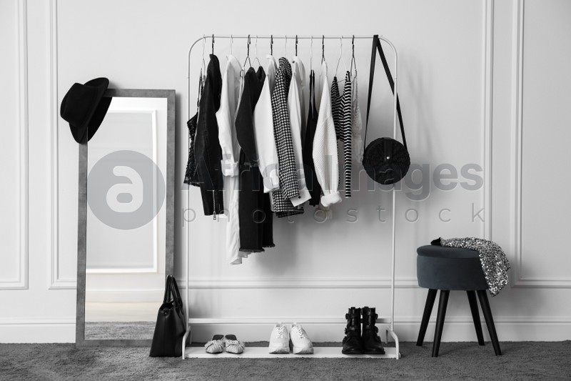 Photo of Rack with stylish clothes in modern dressing room