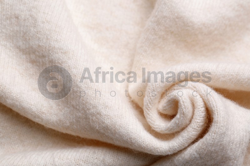 Soft beige knitted fabric as background, top view