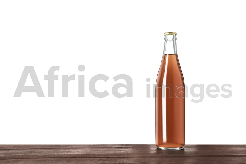 Photo of Bottle of delicious kvass on wooden table against white background