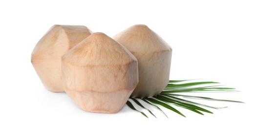 Young peeled coconuts with palm leaf on white background