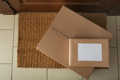 Parcels on rug near door, flat lay. Delivery service