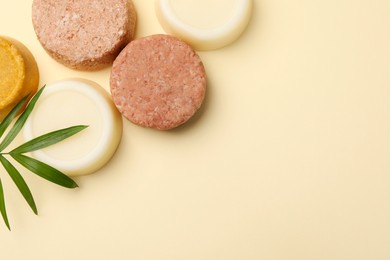 Photo of Flat lay composition of solid shampoo bars and leaf on beige background. Space for text