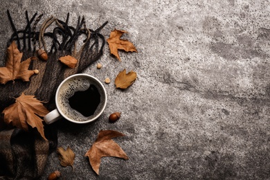 Photo of Flat lay composition with cup of hot drink and autumn leaves on grey table, space for text. Cozy atmosphere