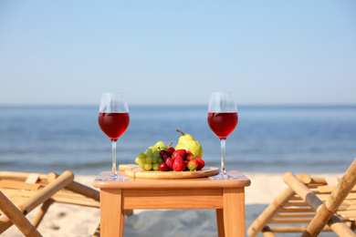Glasses with wine and fruits on table at resort