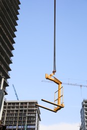 Photo of Tower crane near unfinished buildings against cloudy sky on construction site