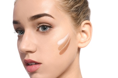Young woman with different shades of skin foundation on her face against white background. Professional makeup