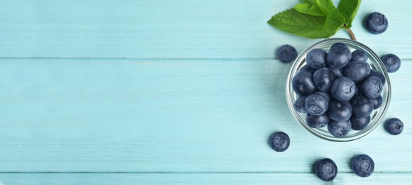 Tasty fresh blueberries on turquoise wooden table, flat lay with space for text. Banner design