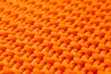 Beautiful orange knitted fabric as background, closeup