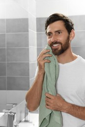 Handsome man drying his beard in bathroom