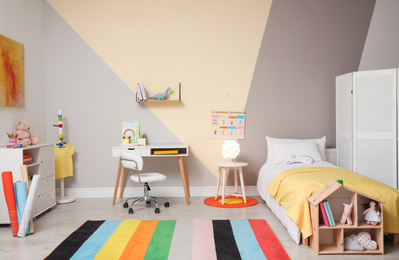 Photo of Stylish child room interior with comfortable bed and desk