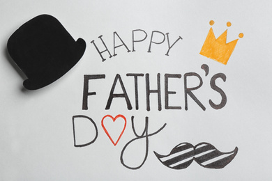 Paper hat on greeting card with phrase HAPPY FATHER'S DAY, top view