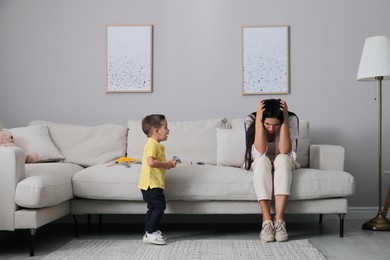 Depressed single mother with child in living room