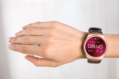 Woman with smart watch displaying time, date and heart rate, closeup