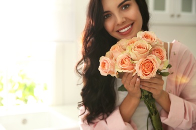 Young woman with beautiful bouquet in kitchen