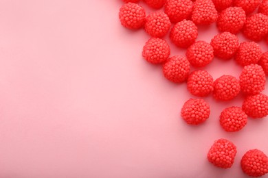 Delicious gummy raspberry candies on pink background, flat lay. Space for text